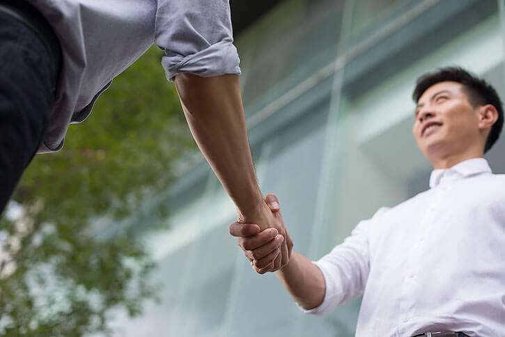 A picture of a person shaking hands with a Chinese manufacturer or supplier, representing the importance of establishing a relationship with a reliable source.